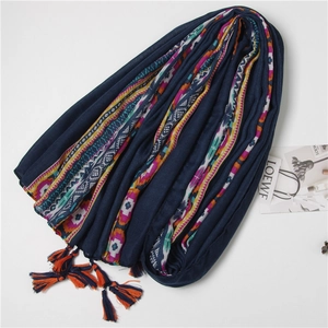 Detail of dark blue ethnic scarf with colorful geometric borders and fringe tassels