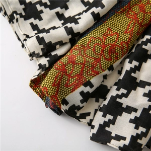 Macro detail of houndstooth scarf showing intricate lace stitching and woven texture