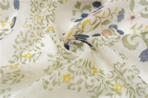 Vue détaillée du tissu en lin de l'écharpe avec imprimés floraux délicats et texture douce