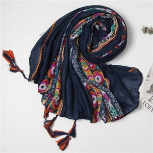 Detail of bohemian geometric print scarf with colorful orange and blue fringe tassels