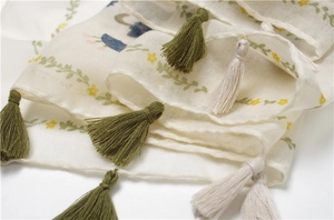 Détail d'imprimé fleuri sur écharpe en lin semi-transparente avec franges faites main