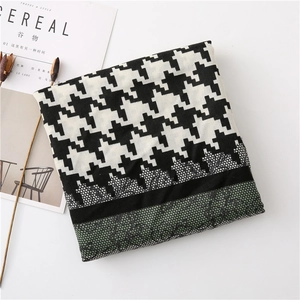 Detail shot of houndstooth scarf with green lace trim and elegant vintage fringe edges