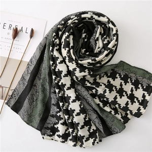 Detail showing the elegant houndstooth pattern and dark green lace stitching of the scarf