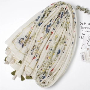 Écharpe en coton et lin à imprimé fleuri avec glands colorés en vue stylisée