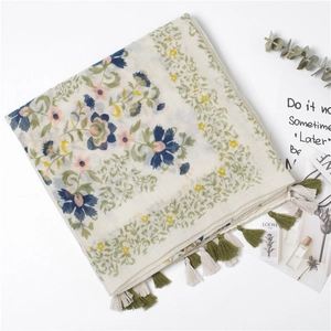 Écharpe bohème en coton et lin à imprimé fleuri avec pompons faits main posée à plat