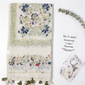 Écharpe en coton et lin à imprimé fleuri avec bordures à pompons sur fond blanc