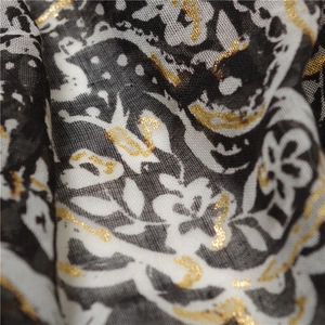 Macro detail of lightweight printed shawl with golden foil paisley motifs and patterns