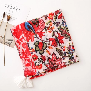 Detail of red floral bali gauze scarf with white tassels and bohemian flower patterns