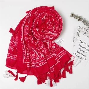 Écharpe rouge à motif cachemire avec longues franges présentée à plat en spirale