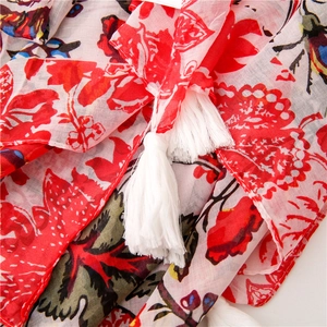 Close-up of red floral voile scarf showing breathable fabric and fine white fringe trim