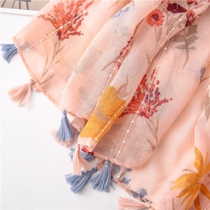Detail of pink floral cotton linen scarf featuring sequins and colorful tassel fringe