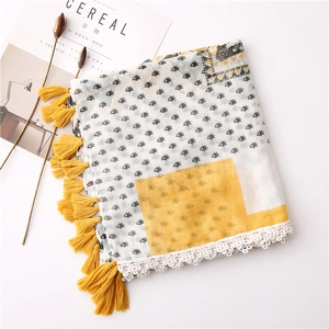 Detail of floral cotton scarf with yellow tassels and white crochet lace border edge