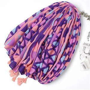 Détail d'une écharpe géométrique douce avec triangles violets et décorations de glands roses