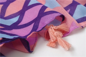 Vue détaillée de l'écharpe en coton et lin à imprimé géométrique avec pompons roses