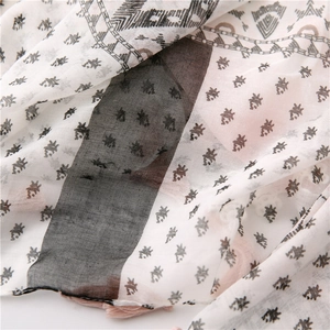 Detailed close-up of cotton linen scarf with vintage prints and pink fringe trim