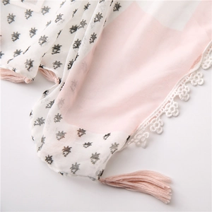 Detail of lace edging and pink silk tassels on a lightweight cotton linen scarf