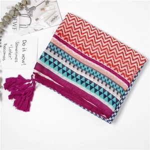 Flat lay of colorful bohemian beach shawl with geometric patterns and fringe details