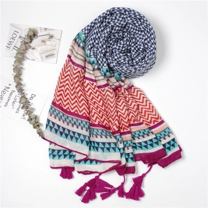 Macro detail of geometric print beach shawl with purple fringe tassels and soft texture