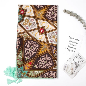 Detail of bohemian silk scarf with geometric prints and mint green fringe tassels