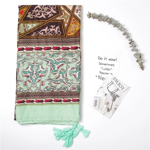 Detail of bohemian scarf with ethnic vine floral prints and mint green fringe tassels