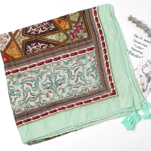 Detail of mint green bohemian scarf with geometric prints and fringe tassels