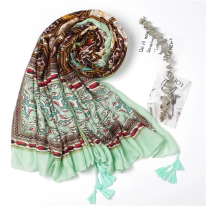 Detail of bohemian silk scarf with geometric patterns and mint green tassels