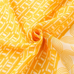 Vue macro d'une écharpe en coton jaune avec motifs géométriques et texture douce