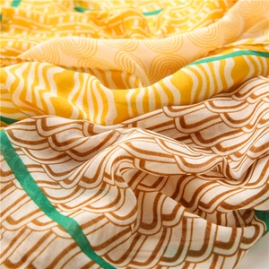 Détail d'une écharpe en mousseline avec motifs géométriques et bordure verte