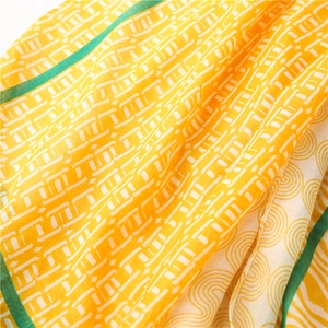 Détail d'une écharpe en lin jaune et beige aux motifs géométriques et spirales