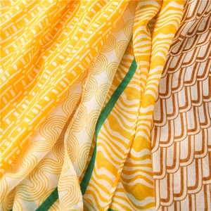Gros plan du tissu léger de l'écharpe avec motif géométrique jaune et texture douce
