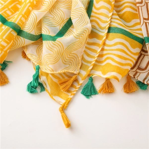 Détail d'écharpe à motif géométrique coloré avec de fines franges jaunes et vertes