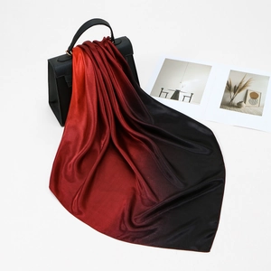 Sciarpa di raso sfumato rosso e nero su una borsa con una lussuosa lucentezza di seta