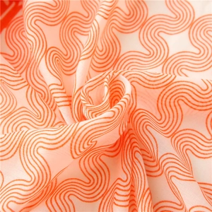 Gros plan sur un motif de vagues orange sur un tissu léger et semi-transparent doux