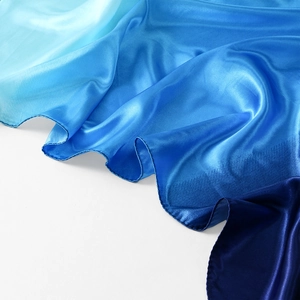 Dettaglio macro dello scialle in raso con sfumatura blu e finitura lucida