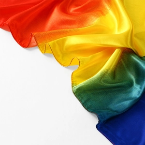 Dettaglio macro del tessuto in raso setoso con sfumatura arcobaleno e finitura lucida