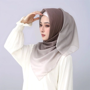 Macro shot of gradient brown to beige chiffon hijab showing fine fabric texture and hem