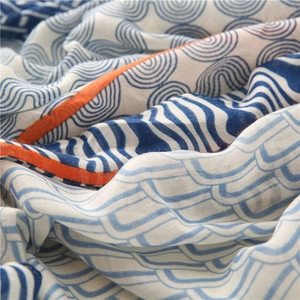 Détail d'écharpe en coton et lin doux avec vagues bleues et motifs orange vifs