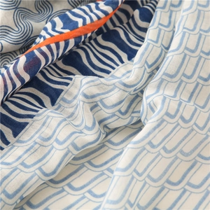 Gros plan d'une écharpe légère en coton et lin avec motif artistique de vagues bleues