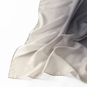 Close-up of voile scarf showing grey gradient texture and fine stitched rolled edge