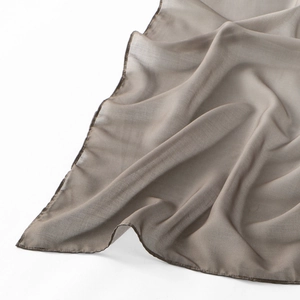 Detail of light brownish-grey voile scarf showing fine texture and hemmed edges