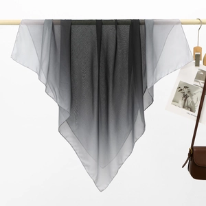 Detailed close-up showing grey to black gradient fabric on a wooden hanger with aesthetic props