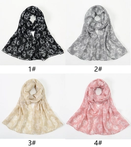 Detail view of floral print scarves in black, grey, cream yellow and light pink colors