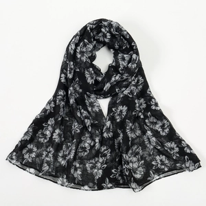 Detail of soft black floral printed scarf featuring lightweight white hibiscus patterns