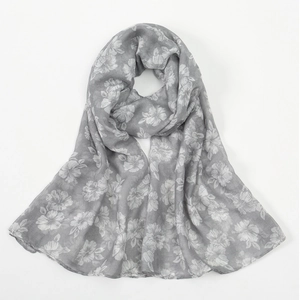 Close-up of soft grey voile scarf featuring white hibiscus floral prints and rolled edges