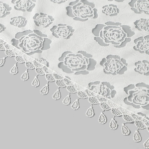 Close-up of white lace bridal veil showing rose floral patterns and teardrop lace tassels