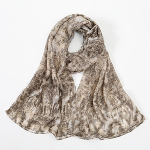Detail of soft floral pashmina scarf featuring abstract marble print in khaki and tan