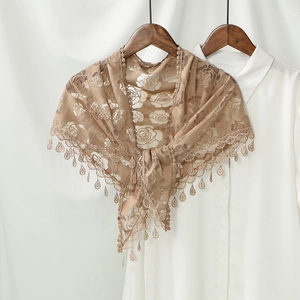 Detailed rose floral lace pattern and water drop fringe tassels on a brown bridal shawl