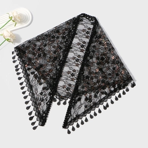 Close-up of black lace shawl featuring sparkling sequins and teardrop fringe details