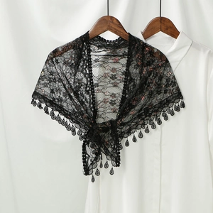Detail of black hollow lace shawl with floral patterns and water drop tassel pendants
