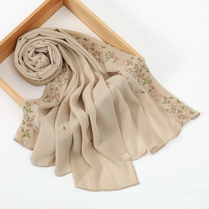 Detailed embroidery of pink flowers and green leaves on beige chiffon headscarf fabric